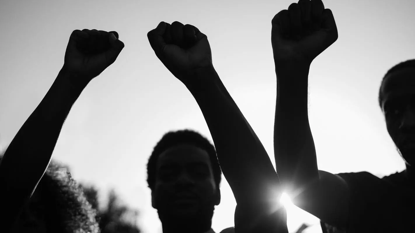 Three people with fists raised 