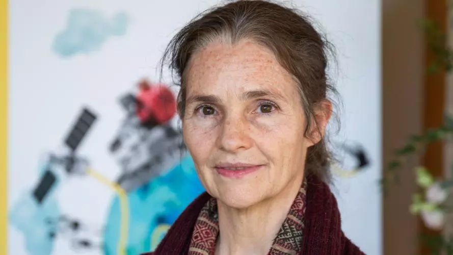 Sabina Alkire wearing a burgundy jacket and a red, brown and camel scarf