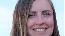 Marie has long brown hair, and is wearing a light blue top