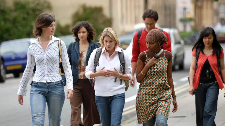 Students in Oxford talking along the street chatting. 