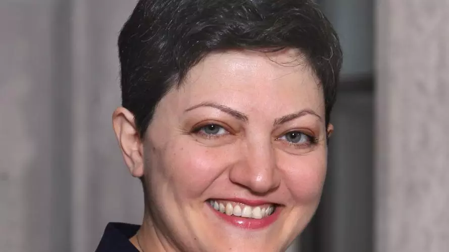 Professor Maryam Alemzadeh has short brown hair. She is wearing a white top and navy blazer