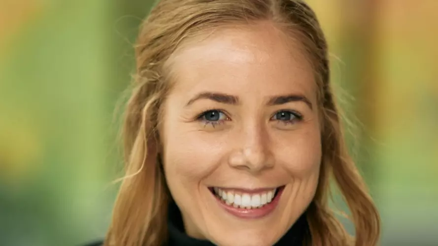Dr Marnie Howlett has shoulder length blonde hair and is smiling broadly at the camera. She's wearing a black jumper.