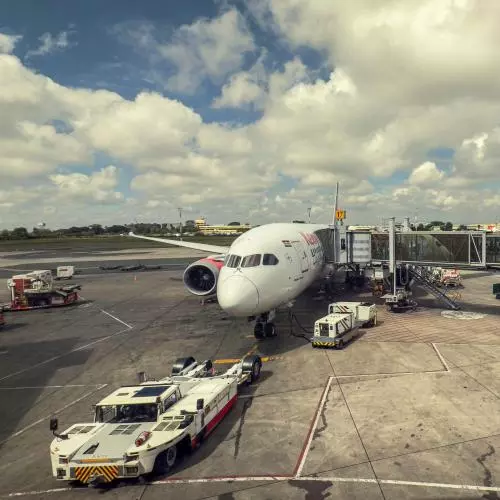 Commercial Airplane with Luggage and Service Vehicles at Jomo Kenyatta International Airport in Nairobi 