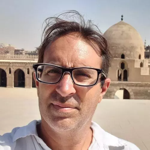 Jorge Luengo has short dark hair and glasses. 