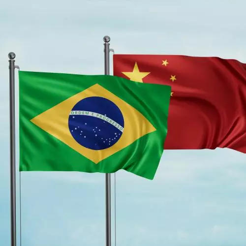 National flags of Brazil and China flying against background of blue sky