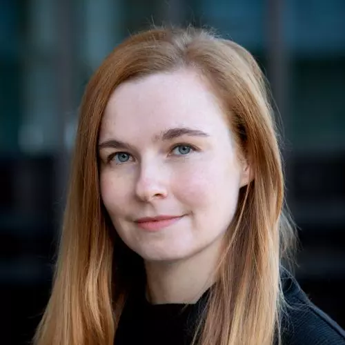 Abigail Branford has long auburn hair and is wearing a black jumper